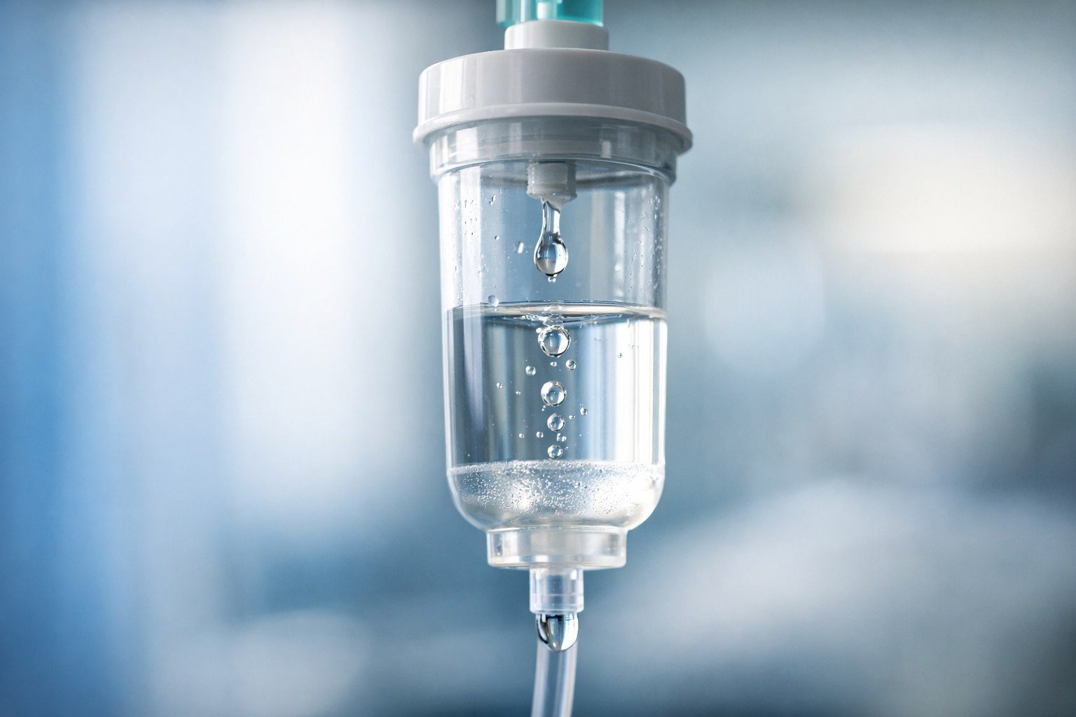 Close-up de câmara de gotejamento de soro hospitalar para cálculo de infusão.