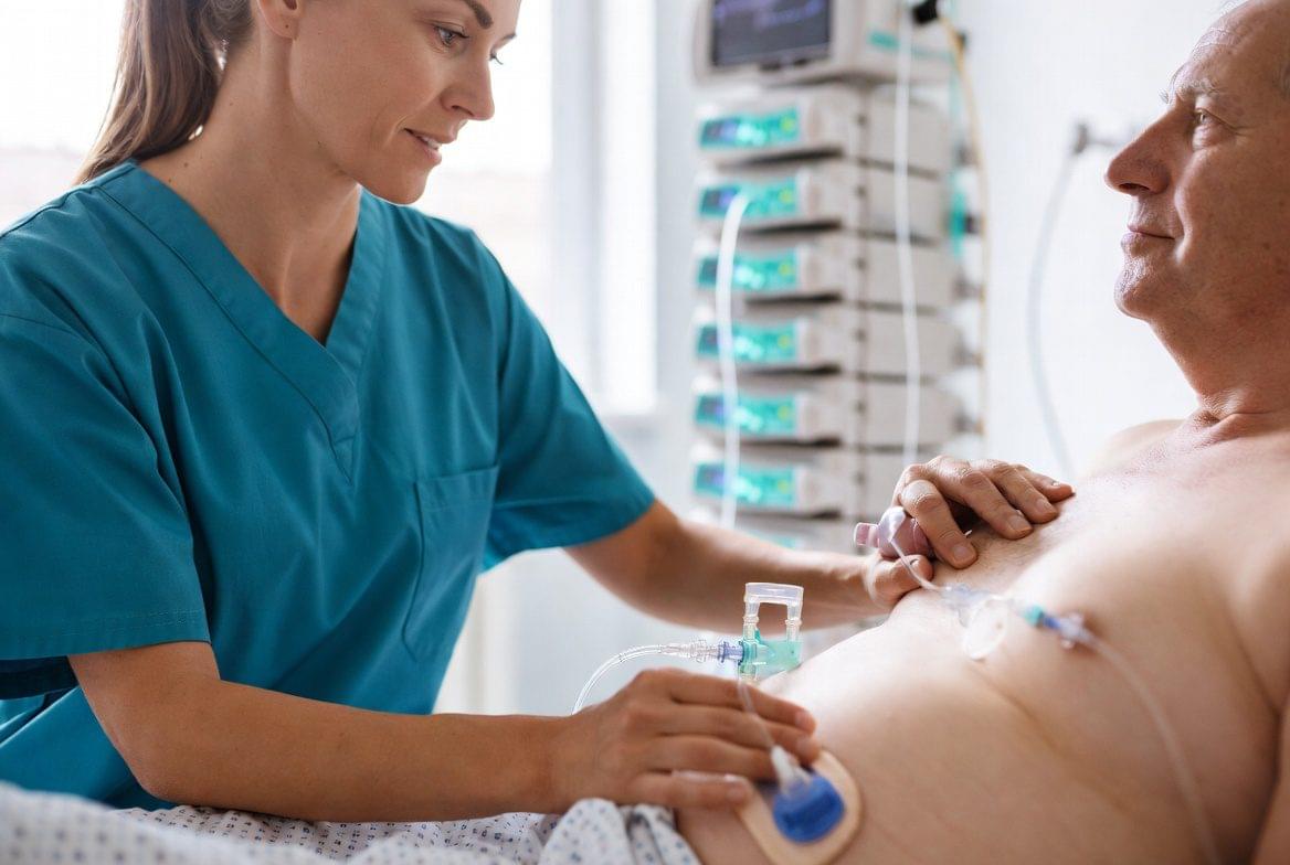 Enfermeira realizando cuidados de enfermagem em gastrostomia em paciente idoso hospitalizado